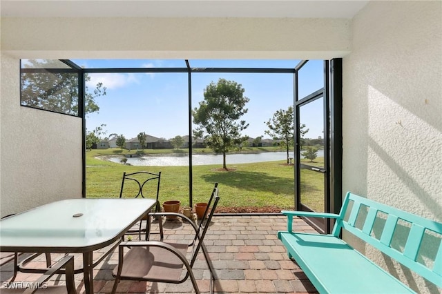 sunroom featuring a water view