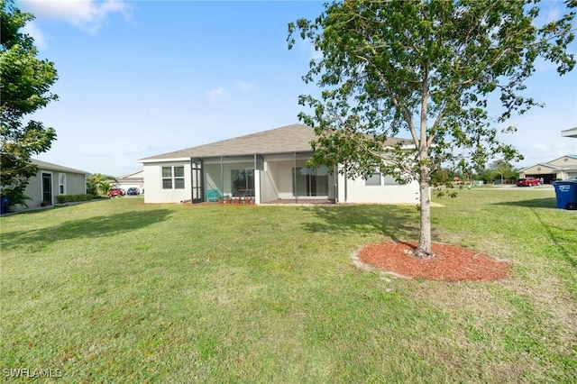 back of house featuring a sunroom and a lawn