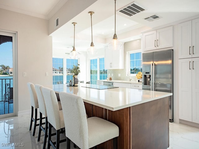 kitchen featuring a large island, white cabinetry, backsplash, hanging light fixtures, and stainless steel refrigerator with ice dispenser