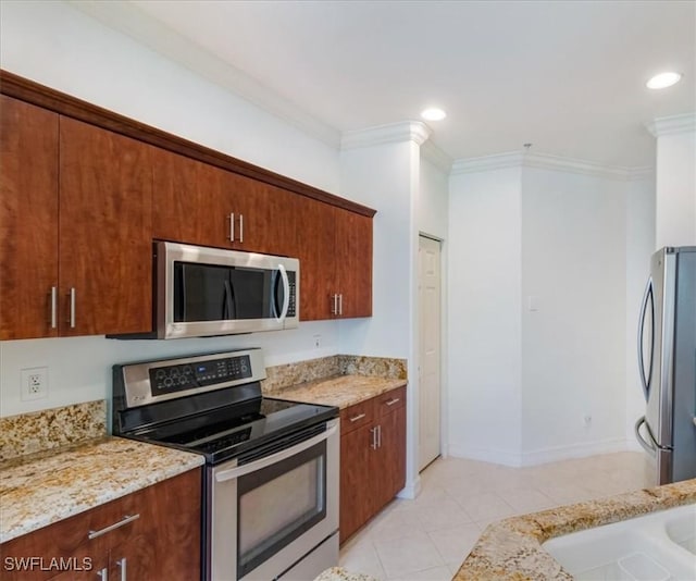 kitchen featuring light stone countertops, light tile patterned floors, stainless steel appliances, and ornamental molding