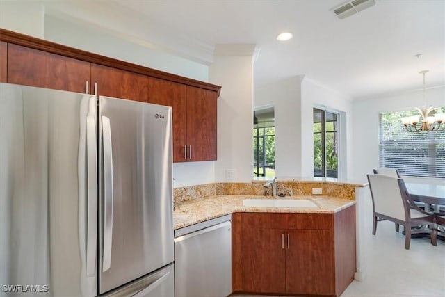 kitchen with sink, hanging light fixtures, an inviting chandelier, kitchen peninsula, and appliances with stainless steel finishes