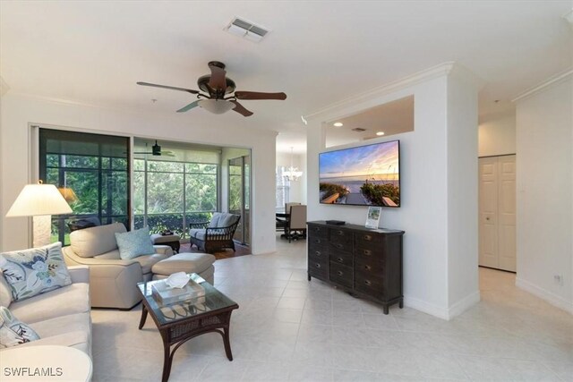 living room with ceiling fan with notable chandelier and ornamental molding