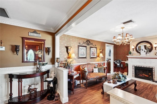 living room featuring crown molding, a high end fireplace, a chandelier, and hardwood / wood-style floors