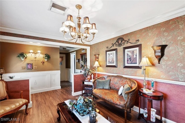 living room featuring light hardwood / wood-style flooring, ornamental molding, and a chandelier