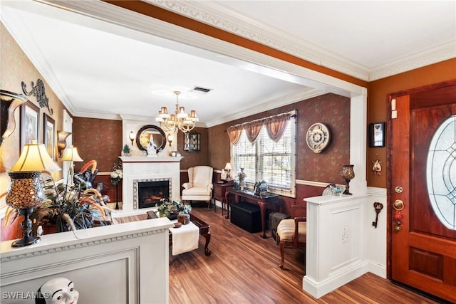 foyer entrance featuring wood-type flooring, a notable chandelier, and crown molding