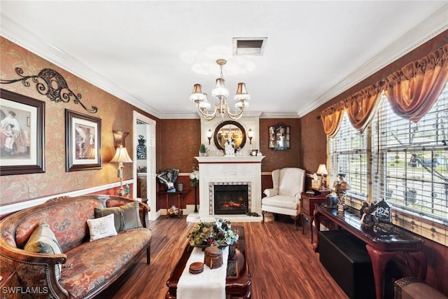 living room featuring dark hardwood / wood-style flooring, ornamental molding, a premium fireplace, and an inviting chandelier