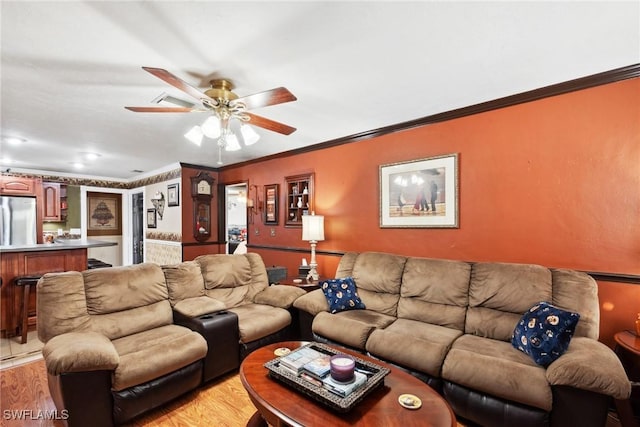 living room with crown molding, ceiling fan, and light hardwood / wood-style flooring