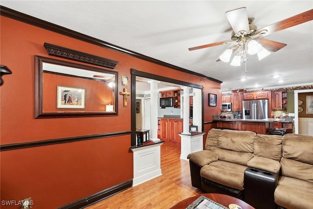 living room with ceiling fan, ornamental molding, and light hardwood / wood-style flooring