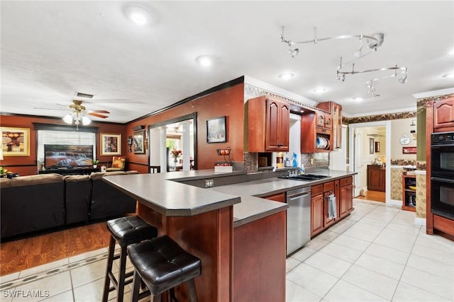 kitchen featuring crown molding, stainless steel dishwasher, a breakfast bar, and sink