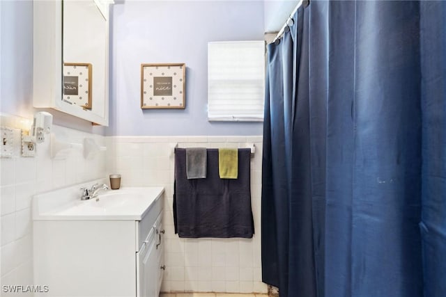 bathroom featuring vanity and tile walls