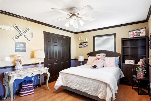 bedroom featuring hardwood / wood-style flooring, ornamental molding, a closet, and ceiling fan