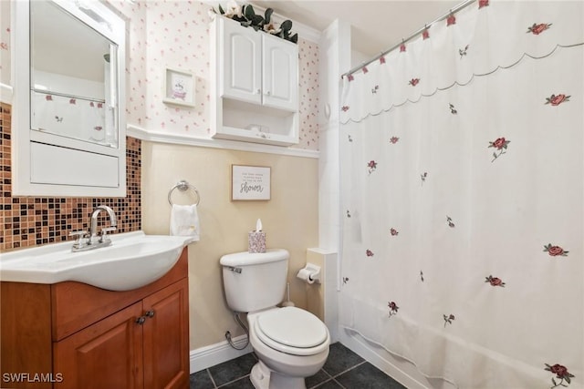 bathroom featuring tile patterned flooring, toilet, vanity, and decorative backsplash