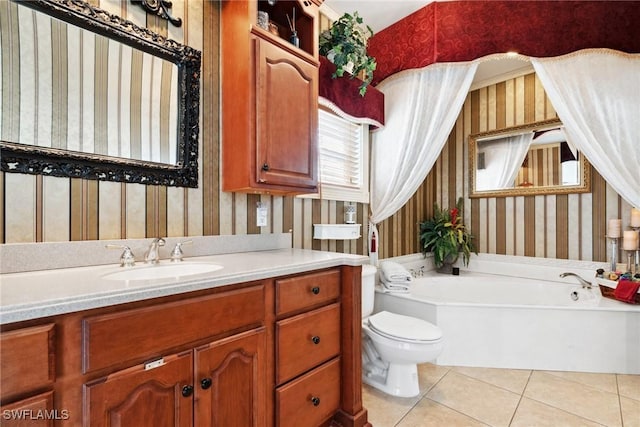 bathroom featuring tile patterned flooring, a bath, vanity, and toilet