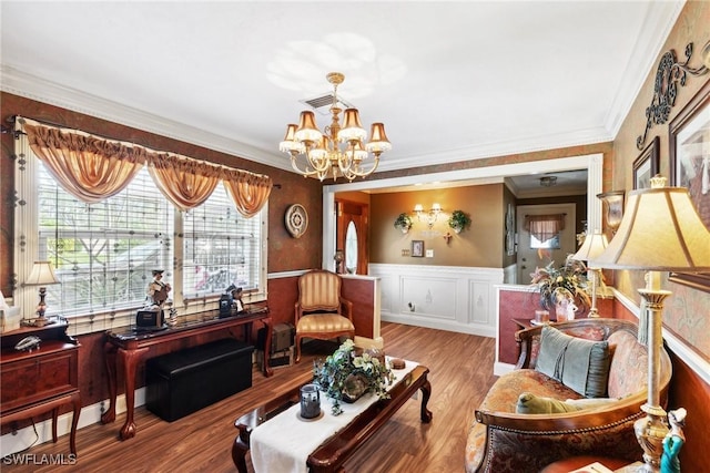 living room with an inviting chandelier, crown molding, and light hardwood / wood-style flooring