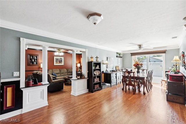 dining room with decorative columns, wood-type flooring, crown molding, and ceiling fan