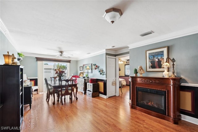 dining space with ornamental molding, light hardwood / wood-style floors, and ceiling fan