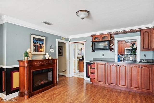 kitchen featuring sink, crown molding, and light hardwood / wood-style flooring