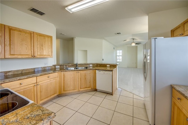 kitchen with white appliances, ceiling fan, dark stone counters, sink, and light tile patterned flooring