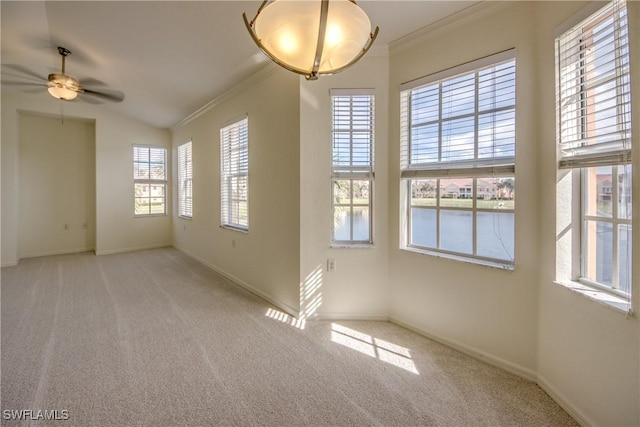 empty room featuring light carpet, ceiling fan, plenty of natural light, and ornamental molding