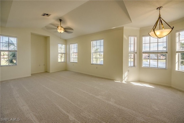 carpeted empty room with vaulted ceiling, ceiling fan, a wealth of natural light, and ornamental molding