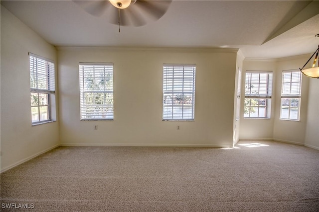 carpeted spare room with ceiling fan, ornamental molding, and vaulted ceiling