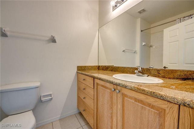 bathroom featuring toilet, vanity, and tile patterned floors