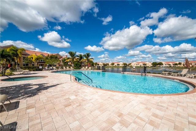 view of swimming pool featuring a community hot tub and a patio