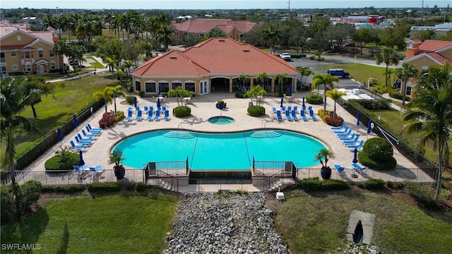 view of swimming pool with a patio, a lawn, and a hot tub