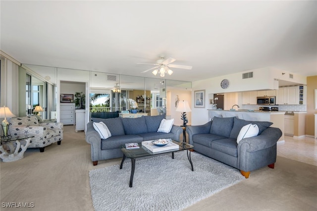 living room featuring light carpet and ceiling fan