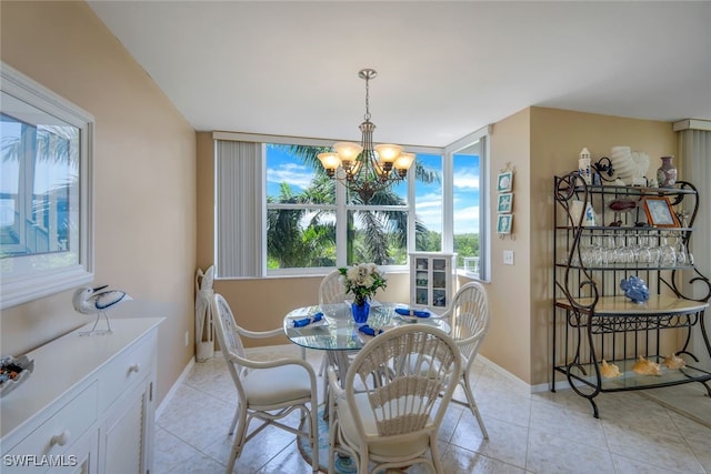 tiled dining space featuring a healthy amount of sunlight and an inviting chandelier