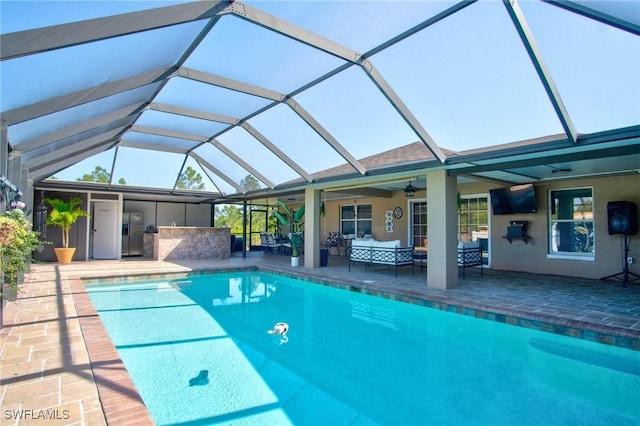 view of swimming pool featuring outdoor lounge area, a patio area, ceiling fan, and a lanai