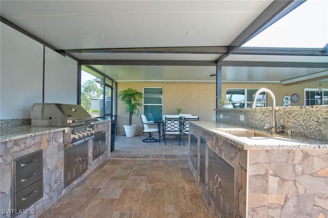 view of patio featuring area for grilling, sink, and an outdoor kitchen