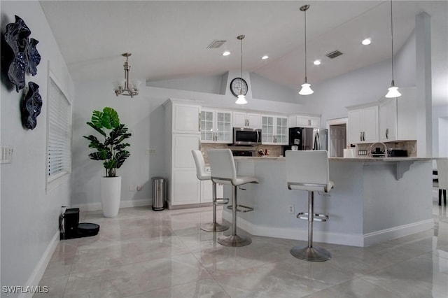 kitchen with decorative backsplash, stainless steel appliances, and white cabinetry