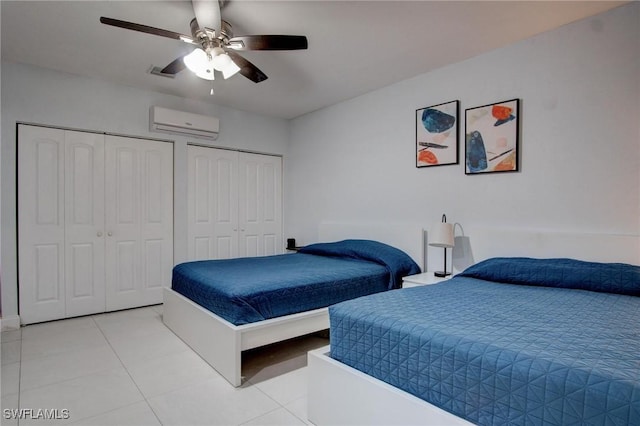 tiled bedroom featuring ceiling fan, an AC wall unit, and multiple closets