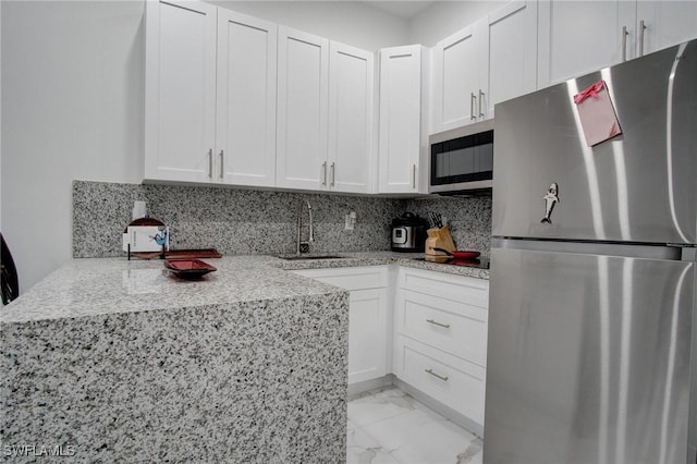 kitchen featuring white cabinets, decorative backsplash, stainless steel appliances, and sink