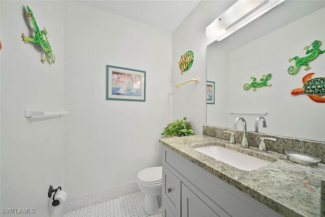 bathroom with tile patterned flooring, vanity, and toilet