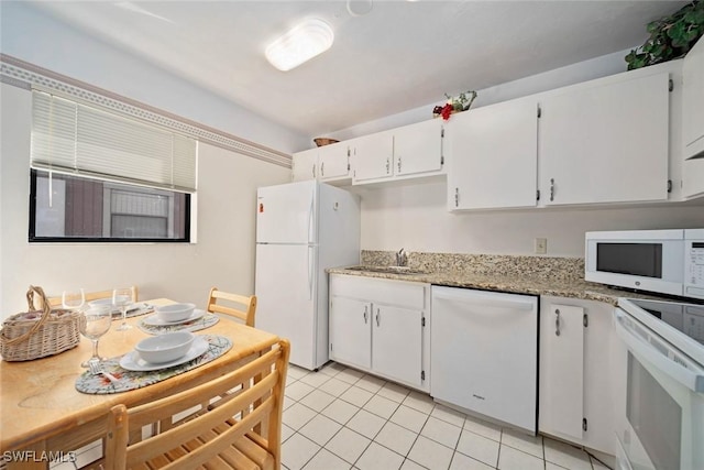 kitchen featuring white cabinetry, sink, light stone countertops, white appliances, and light tile patterned floors