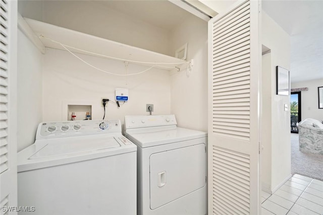 laundry room featuring light colored carpet and separate washer and dryer