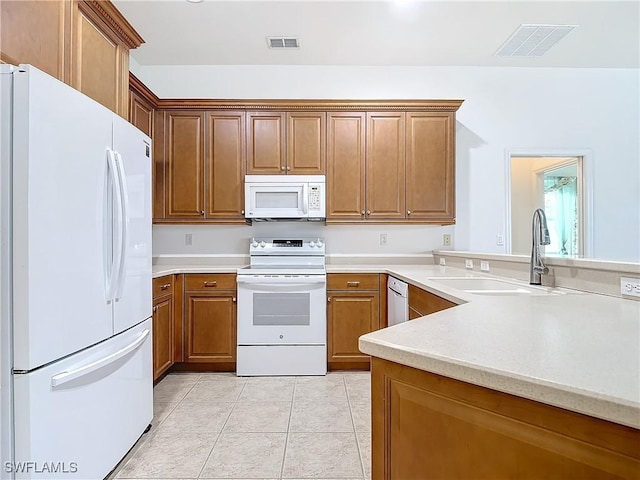 kitchen featuring sink, light tile patterned floors, and white appliances