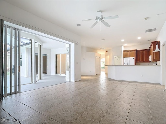 unfurnished living room featuring ceiling fan and light tile patterned floors