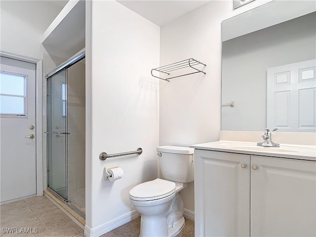 bathroom with tile patterned floors, vanity, toilet, and a shower with door