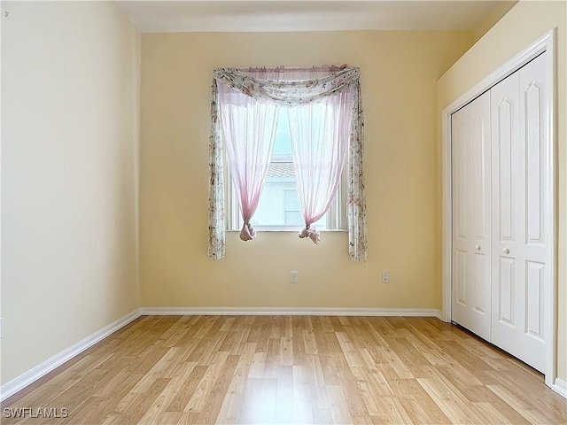 unfurnished bedroom with a closet and light hardwood / wood-style flooring