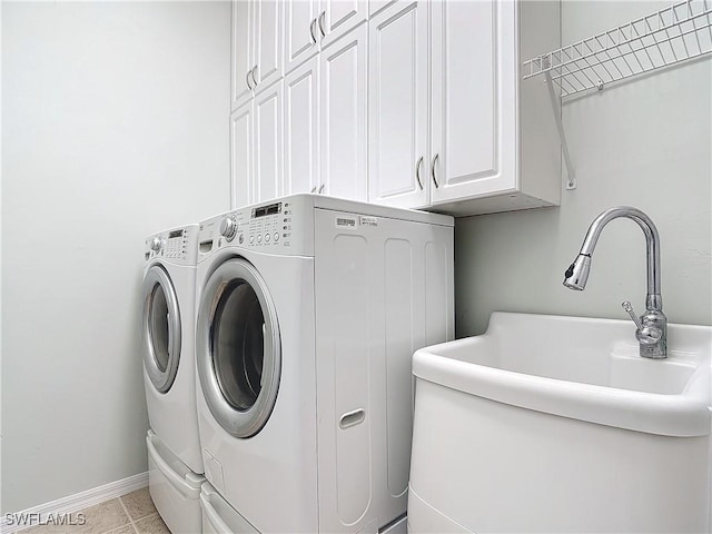 laundry area with cabinets, sink, light tile patterned floors, and washer and clothes dryer