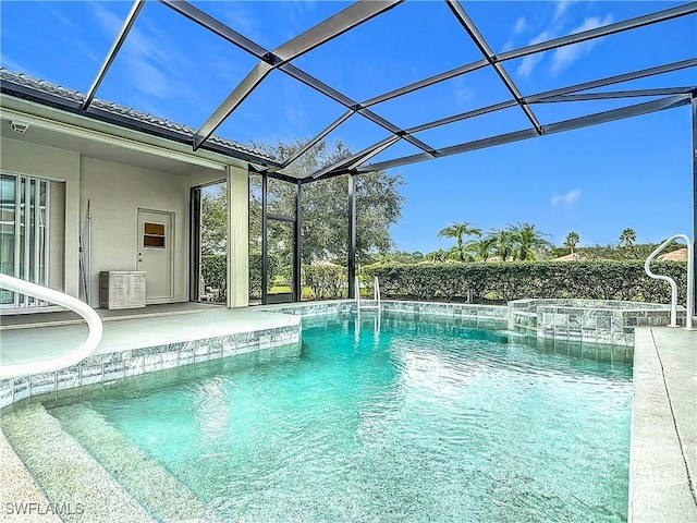 view of pool with an in ground hot tub and glass enclosure