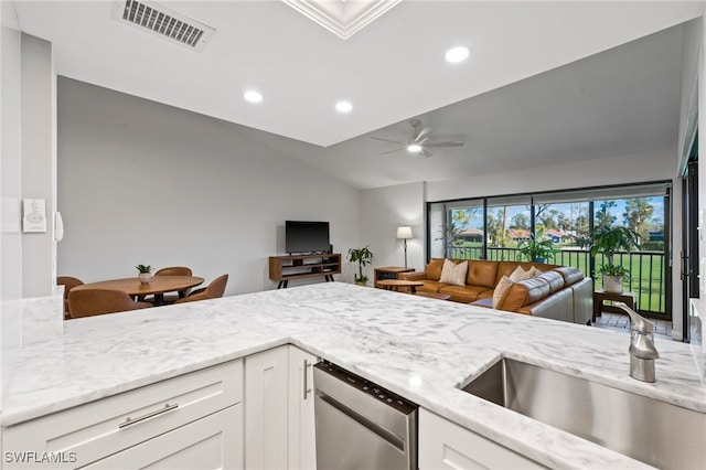 kitchen with light stone countertops, ceiling fan, sink, dishwasher, and white cabinetry