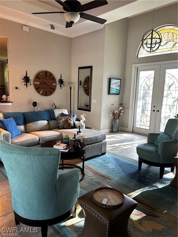 living room with french doors, ceiling fan, and crown molding