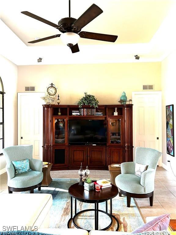 living room featuring light tile patterned floors and a raised ceiling