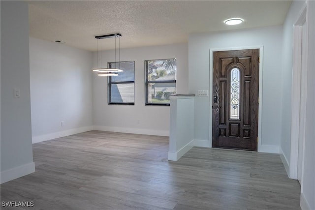 entryway with wood-type flooring and a textured ceiling