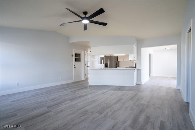 unfurnished living room with ceiling fan, lofted ceiling, and light hardwood / wood-style floors