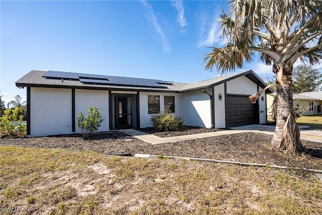 view of front facade with a garage and solar panels